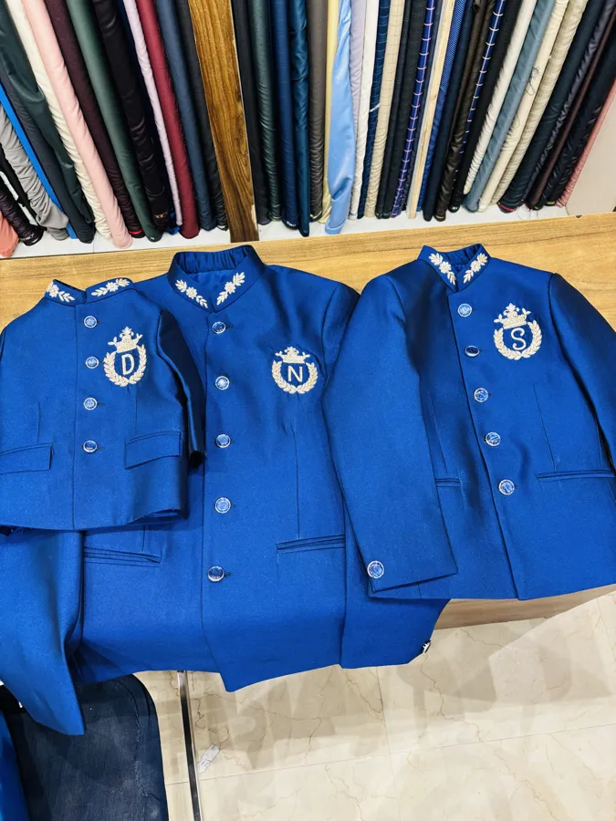 Three royal-blue bandhgalas, each embroidered with a crowned initial in silver